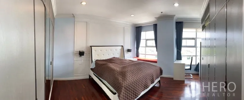 Condominium for rent in Ratchathewi, Bangkok - Panoramic view of the master bedroom showing bay windows and extensive built-in cabinetry.