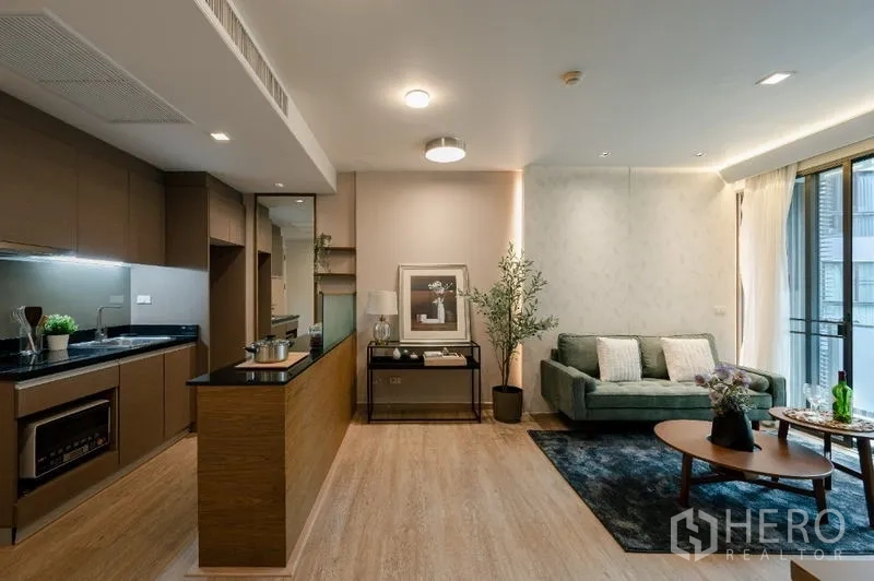 Condominium for sale - Open-plan kitchen and lounge layout with wood flooring and natural light.