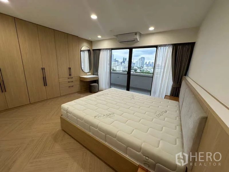 公寓 出租在Watthana, Bangkok - 卧室配整墙衣柜、弧形梳妆台与落地窗帘