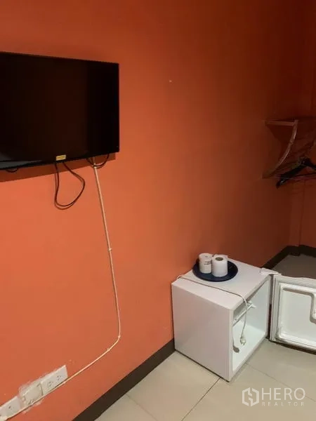 Retail Space for rent in Khlong Toei, Bangkok - Wall-mounted TV and open mini fridge with hanging rack in a guest room.