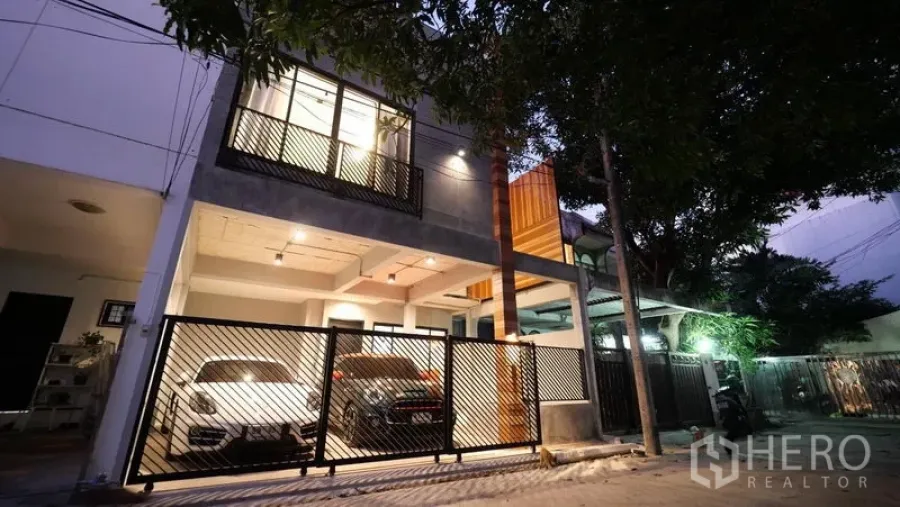 ทาวน์เฮาส์ ให้เช่าในKhlong Toei, Bangkok - ด้านหน้าทาวน์เฮ้าส์สมัยใหม่ พร้อมประตูรั้วและที่จอดรถ 2 คันยามค่ำ