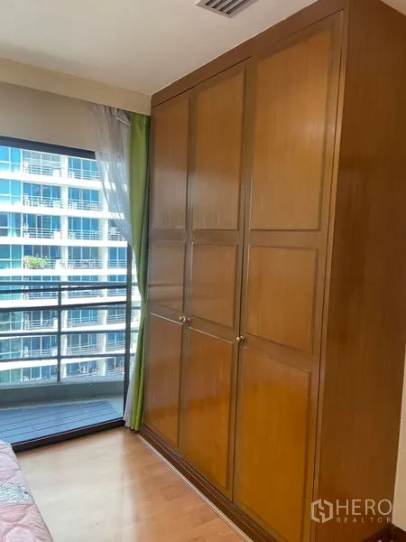 公寓 出租在Pathum Wan, Bangkok - 落地窗旁的内置木质衣柜，享都市景观。