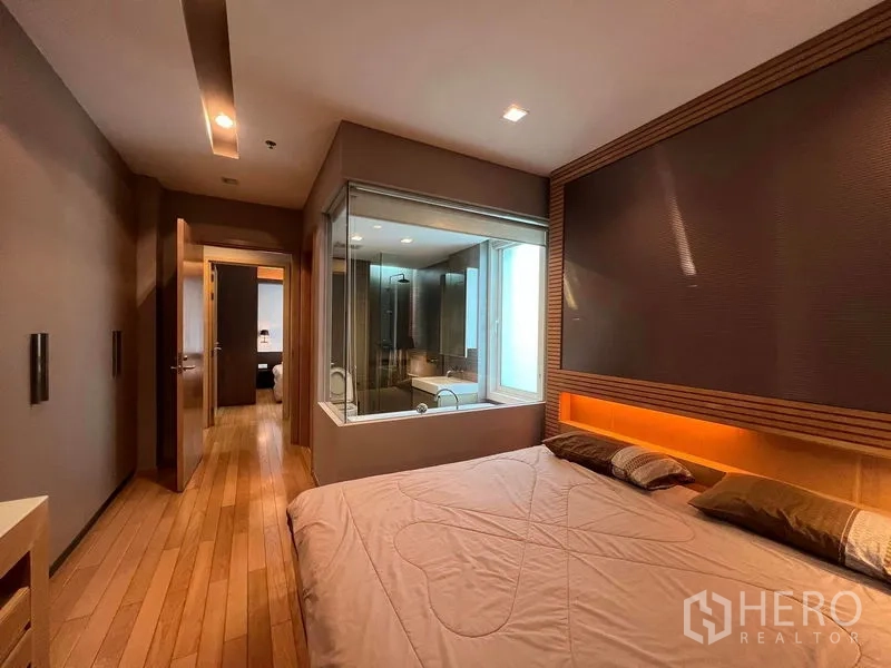 公寓 出租在Khlong Toei, Bangkok - 主卧配木地板与玻璃墙套卫，内置灯带氛围感。