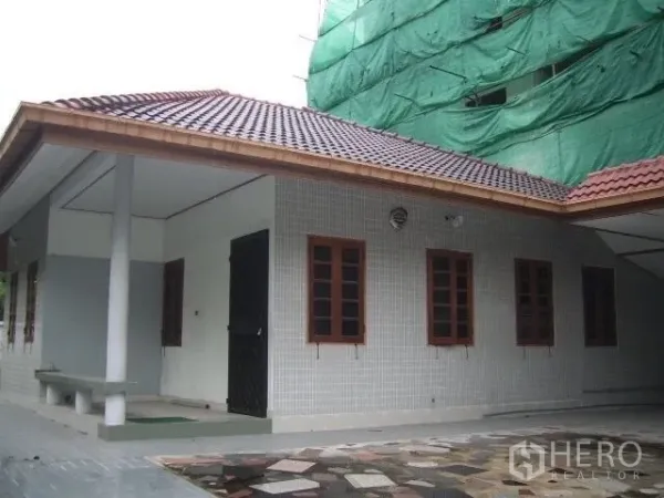 Retail Space for rent in Watthana, Bangkok - Single-storey building exterior with tiled roof, multiple wooden-framed windows and large paved forecourt.