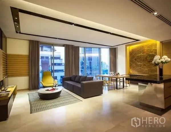 Condominium for rent in Bang Rak, Bangkok - Open-plan living and dining room with floor-to-ceiling windows, city view, and a feature-lit wall.