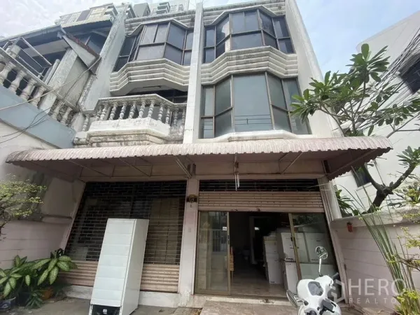 Retail Space for rent in Watthana, Bangkok - Close-up of the retail facade with awning, glass storefront and roller shutters at ground level.