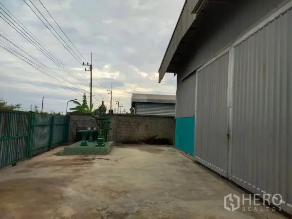 คลังสินค้า ขายในLam Luk Ka, Pathum Thani - ลานคอนกรีตข้างโกดัง ประตูรั้วเลื่อน พร้อมศาลพระภูมิ