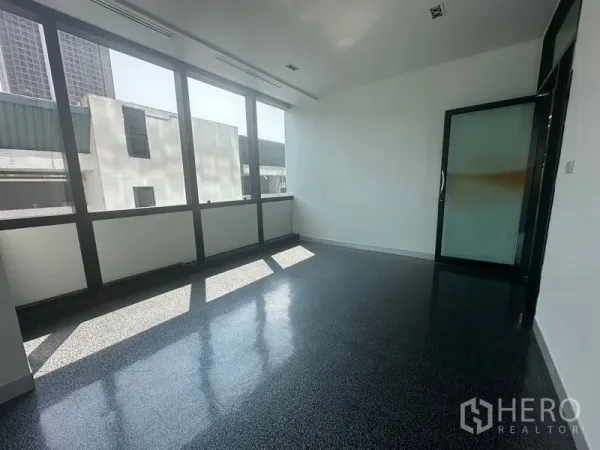 Office Space for rent in Khlong Toei, Bangkok - Sunlit private office with large windows and a sliding glass door.