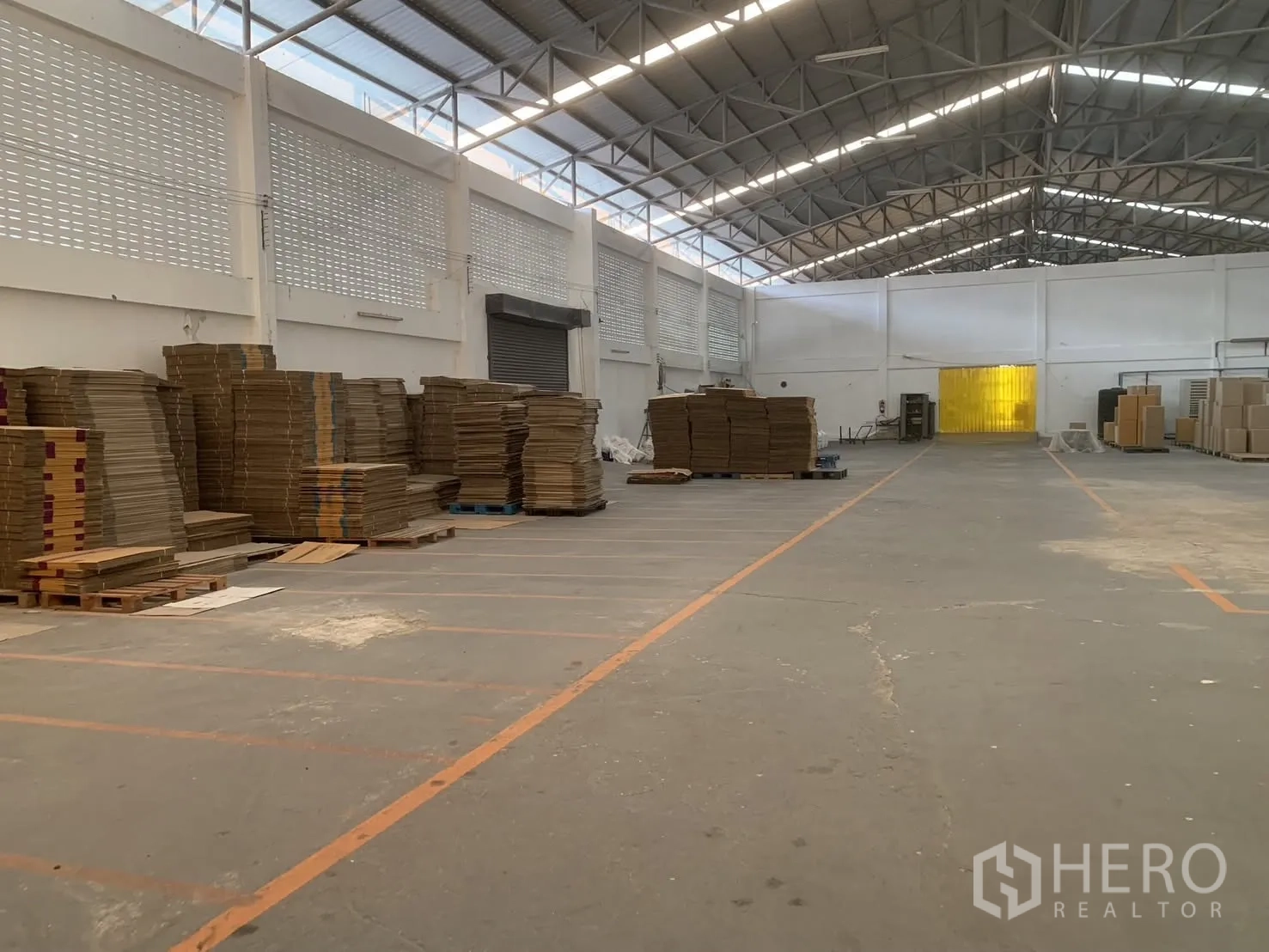 仓库 for rent in Bang Phli, Samut Prakan - 仓库大面积地坪，见卷帘门、通风砖墙与托盘堆放。