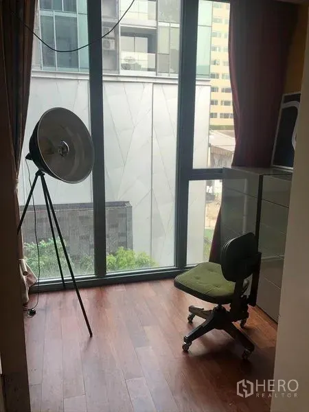 公寓 出售在Watthana, Bangkok - 落地窗角落，木地板，摄影灯与椅子，可眺望城市建筑。
