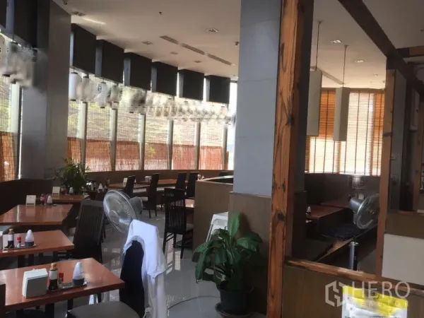 Retail Space for rent in Khlong Toei, Bangkok - Fitted restaurant-style interior with wooden tables, booth seating, large windows and pendant lights.