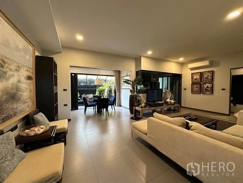 Townhouse for rent or sale in Bang Phli, Samut Prakan - Open-plan living and dining room with sliding doors to the patio and tiled flooring.
