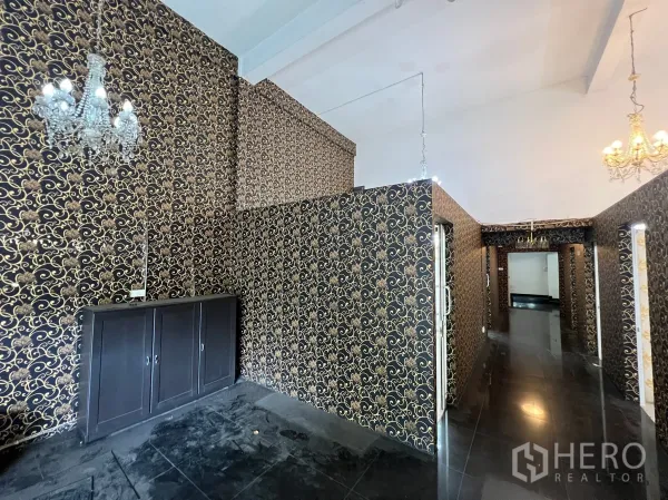 Shophouse for rent in Khlong Toei, Bangkok - Corridor and display area with ornate black-gold wallpaper and a storage cabinet.