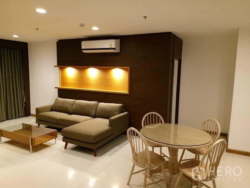 คอนโด ให้เช่าในSathon, Bangkok - ห้องนั่งเล่นกว้าง โซฟาเข้ามุม ไฟส่องชั้นโชว์ แอร์ และโต๊ะกินข้าวทรงกลม