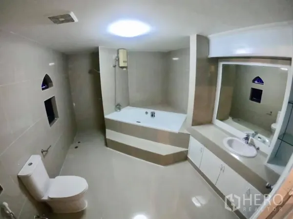 联排别墅 出租在Watthana, Bangkok - 宽敞瓷砖浴室，带浸泡浴缸、独立淋浴、大镜面与坐便器。