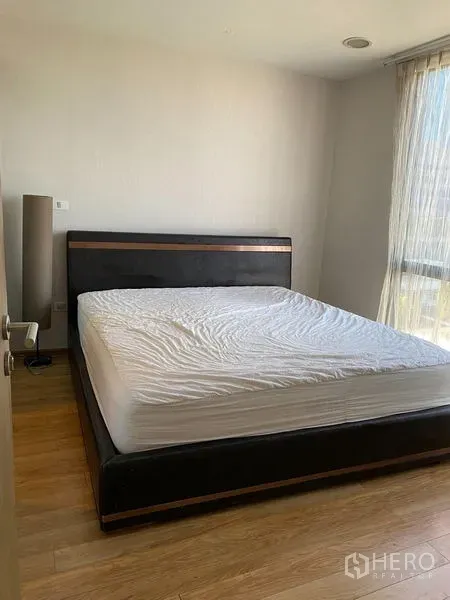 Condominium for rent or sale in Phaya Thai, Bangkok - Bright master bedroom with king bed, wood flooring and a large window with sheer curtains.