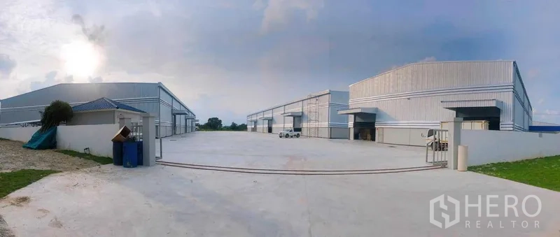 货栈 出租在Ban Bueng, Chon Buri - 多栋现代仓库的全景，配有宽阔混凝土作业场地，便于大车调头。