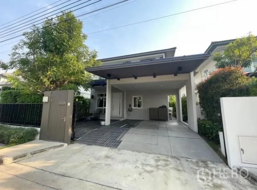 Detached House for rent in Lat Krabang, Bangkok - Modern two-storey house exterior with covered two-car carport, gate and trees