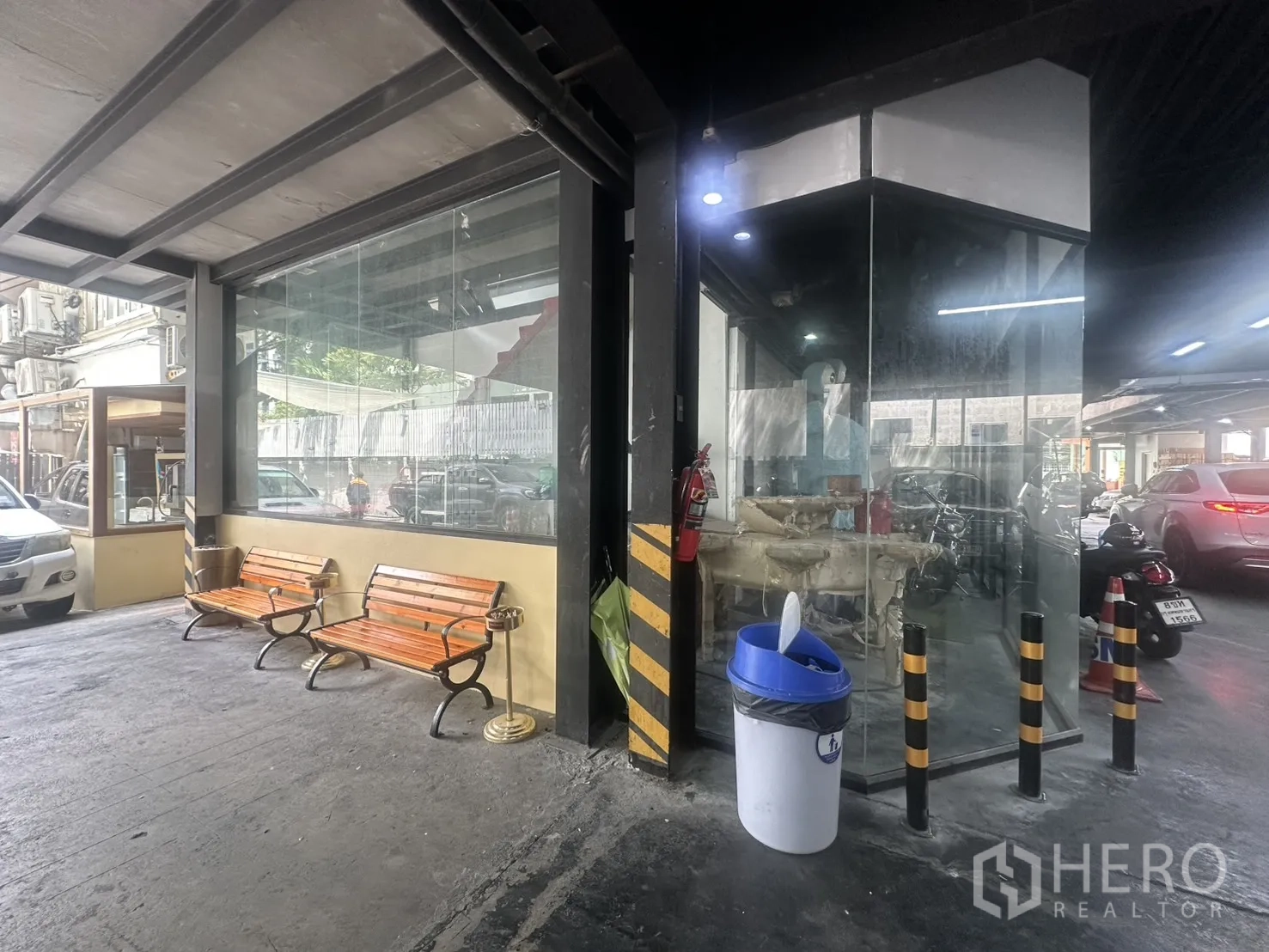 零售空间 for rent in Watthana, Bangkok - 转角玻璃店面位于有顶通道下，设有长椅并临近车道。