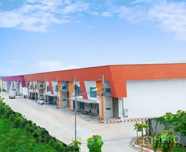 Factory for rent in Pluak Daeng, Rayong - Modern industrial estate block with multiple loading bays, wide internal road and landscaped surrounds.