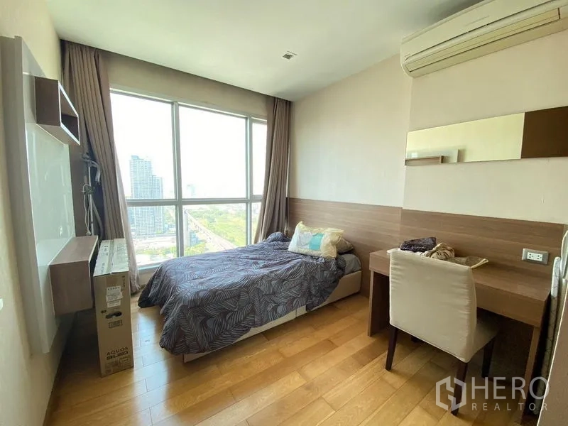 公寓 出售在Ratchathewi, Bangkok - 采光明亮的卧室，带书桌与落地窗，可观赏曼谷天际线。
