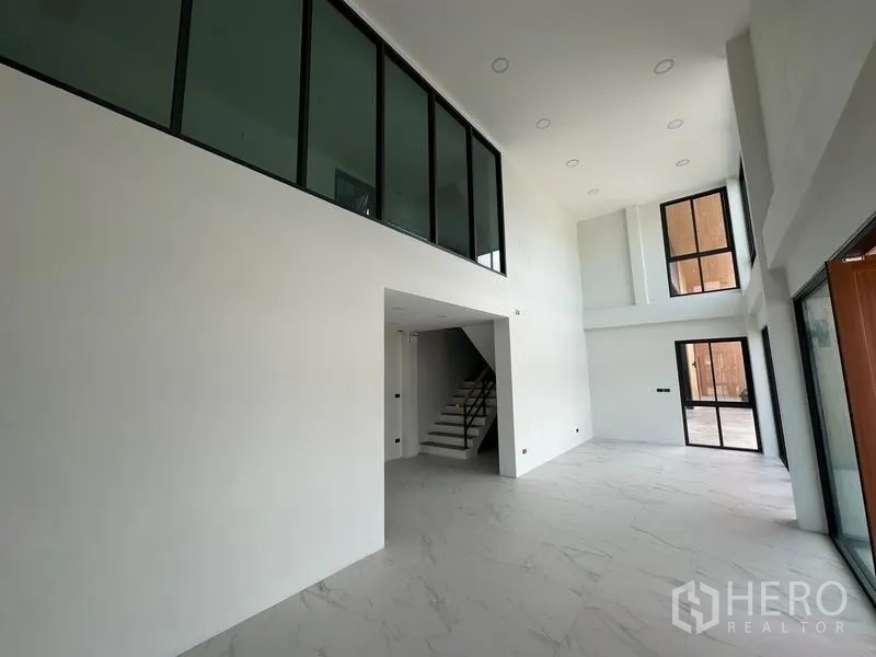Warehouse for sale in Lam Luk Ka, Pathum Thani - Office area with double-height ceiling, mezzanine and large tinted glass panels.