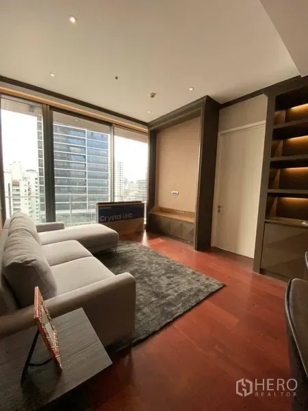 公寓 出租在Watthana, Bangkok - 明亮客厅，灰色沙发与地毯，落地窗俯瞰曼谷天际线。