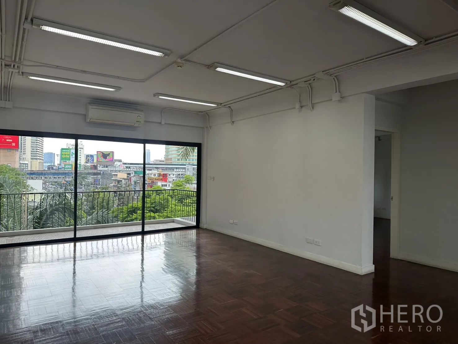 Office Space for rent in Watthana, Bangkok - Open office area with sliding glass doors to a railing terrace and skyline outlook.