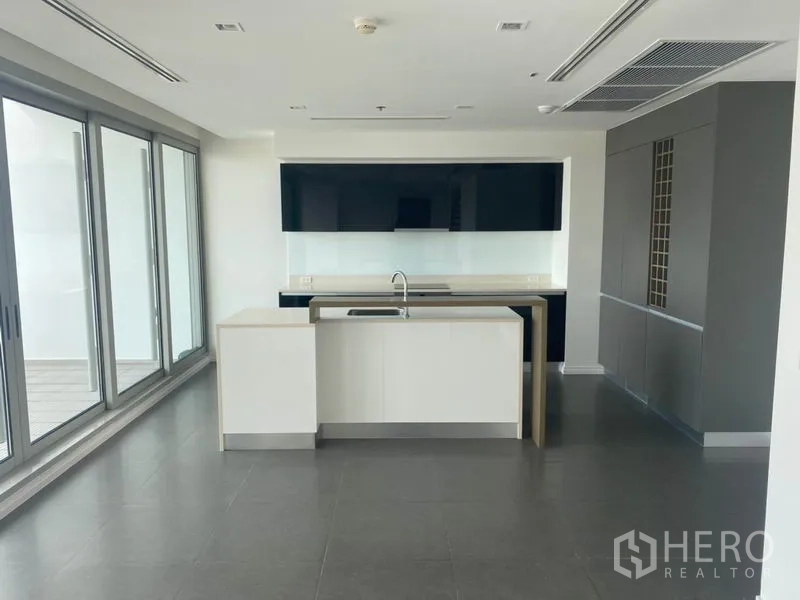公寓 出租或出售在Khlong San, Bangkok - 当代岛台厨房，旁连滑门通往露台。