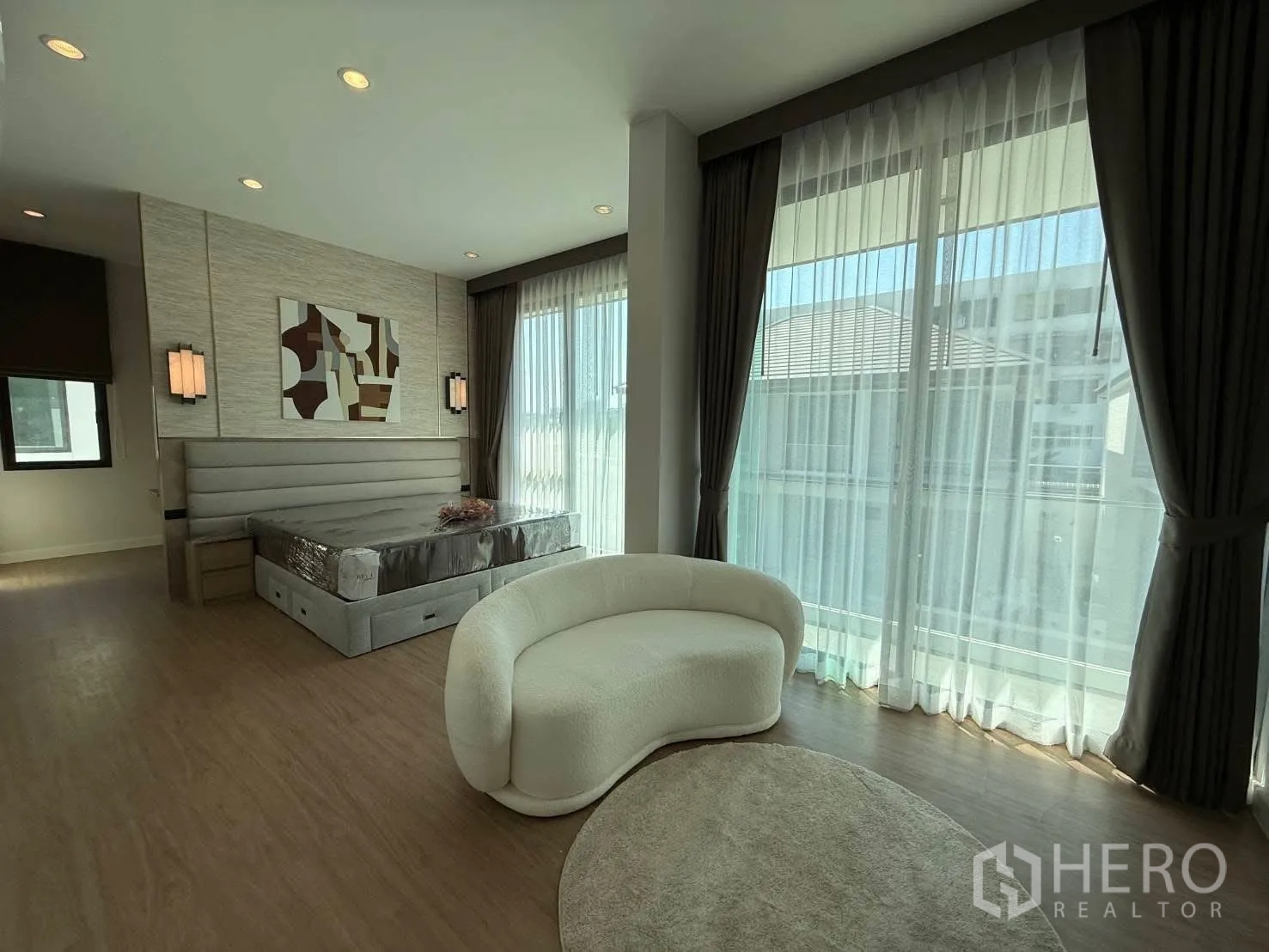 独栋房屋 for rent in Bang Phli, Samut Prakan - 主卧宽敞，软包床头、抽象画与弧形沙发，大面积采光。
