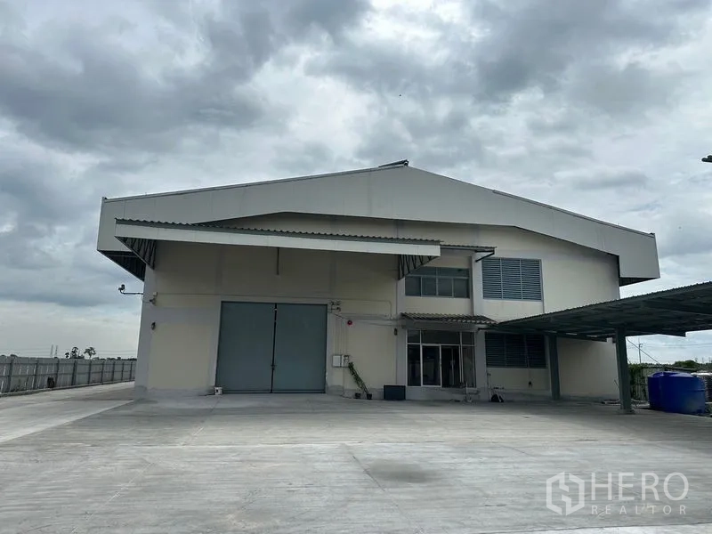 工厂 出租在Lam Luk Ka, Pathum Thani - 建筑长侧立面，带雨棚走道与多处装卸门。