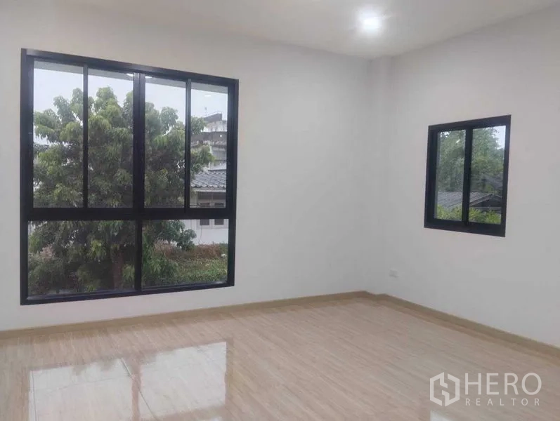 Detached House for sale in Phra Khanong, Bangkok - Corner bedroom with big windows and leafy tree outlook.