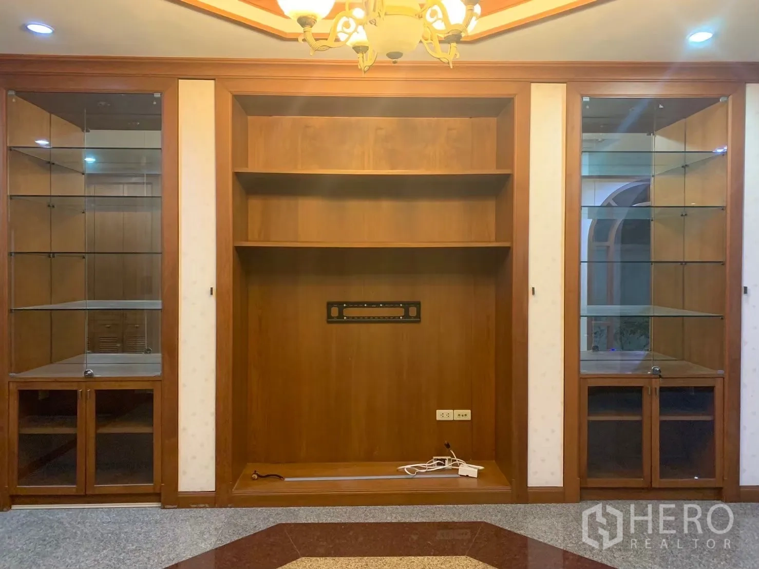 Detached House for rent in Watthana, Bangkok - Built-in wooden wall unit with glass display cabinets in the living room.
