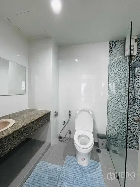 Shophouse for rent in Watthana, Bangkok - White bathroom showcasing a granite vanity, toilet and walk-in shower.