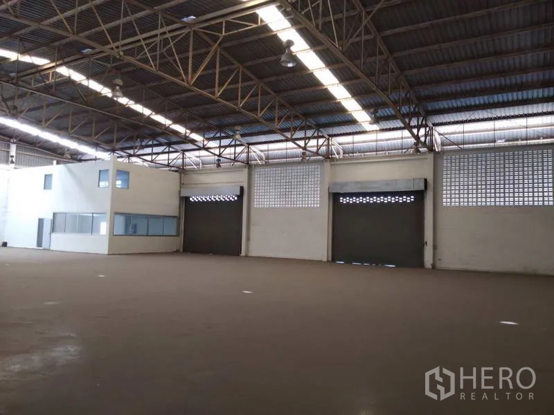 货栈 出租在Bang Phli, Samut Prakan - 开阔仓库大厅，钢桁架屋顶，三道卷帘门与内置办公室。