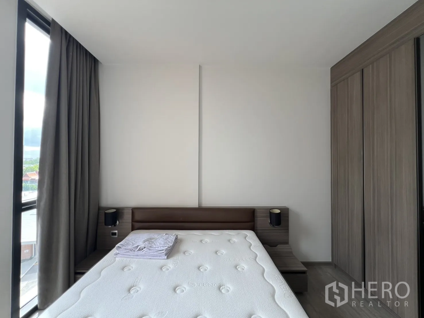 คอนโด for rent in Watthana, Bangkok - ห้องนอนพร้อมเตียงขนาดใหญ่ โต๊ะข้างเตียง และตู้เสื้อผ้าบิวท์อินข้างหน้าต่าง.
