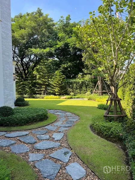 Detached House for rent or sale in Lat Krabang, Bangkok - Landscaped garden with a curved stone pathway and mature trees.