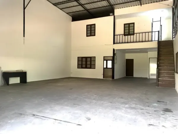 Warehouse for rent in Lam Luk Ka, Pathum Thani - Open-plan storage hall with white walls, upper-level office rooms, and wide clear floor area.