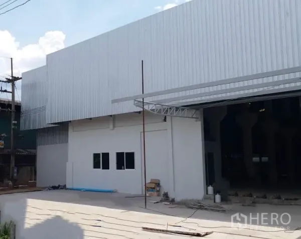 โรงงาน ให้เช่าในKrathum Baen, Samut Sakhon - ด้านหน้าอาคารโรงงานผนังเมทัลชีท พร้อมลานจอดและช่องเปิดขนาดใหญ่สำหรับขนถ่ายสินค้า