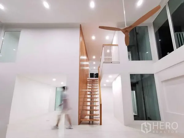 带办公室的家 出售在Suan Luang, Bangkok - 极简挑高大厅，木质开放楼梯与大型吊扇