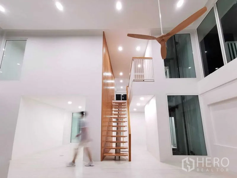 带办公室的家 出售在Suan Luang, Bangkok - 极简挑高大厅，木质开放楼梯与大型吊扇