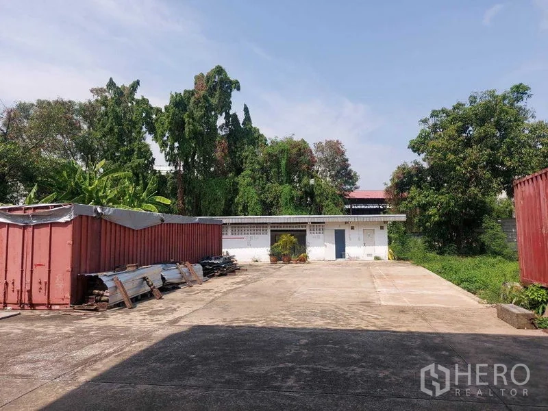 คลังสินค้า ให้เช่าในMin Buri, Bangkok - ลานเก็บสินค้าโล่ง พื้นคอนกรีต มีตู้คอนเทนเนอร์และต้นไม้รายรอบพื้นที่