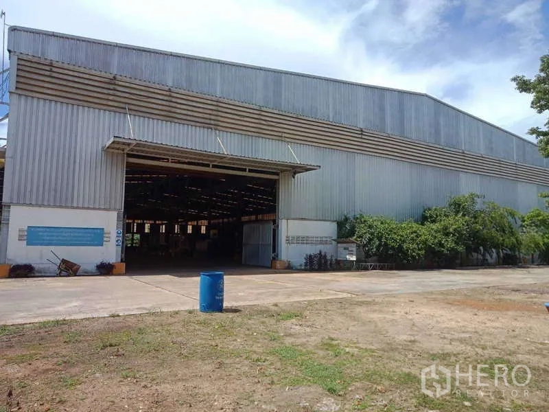 Factory for sale in Chachoengsao - Main warehouse entrance with a high rolling door opening to a brightly lit shop floor.