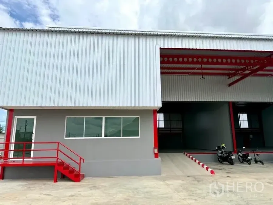 Warehouse for rent in Bang Bo, Samut Prakan - Warehouse exterior with office entrance, windows, steps, and a covered loading bay.