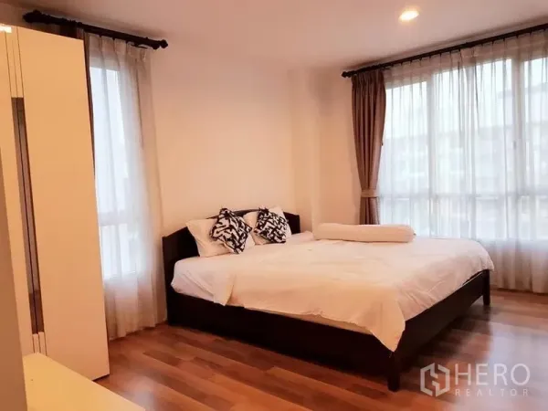 Condominium for rent in Phaya Thai, Bangkok - Spacious master bedroom with large windows, wooden flooring and a king bed under soft lighting.