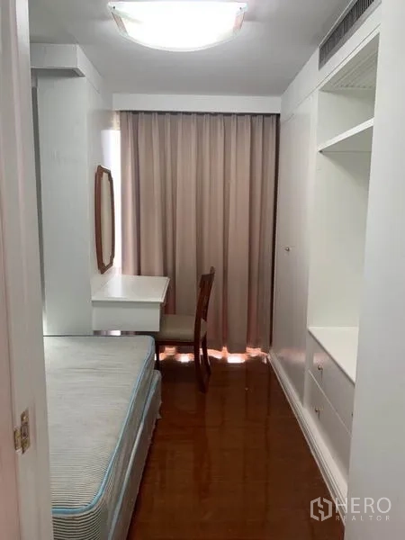 Condominium for sale in Watthana, Bangkok - Compact second bedroom featuring a built-in wardrobe, work desk, and window with blackout curtains.
