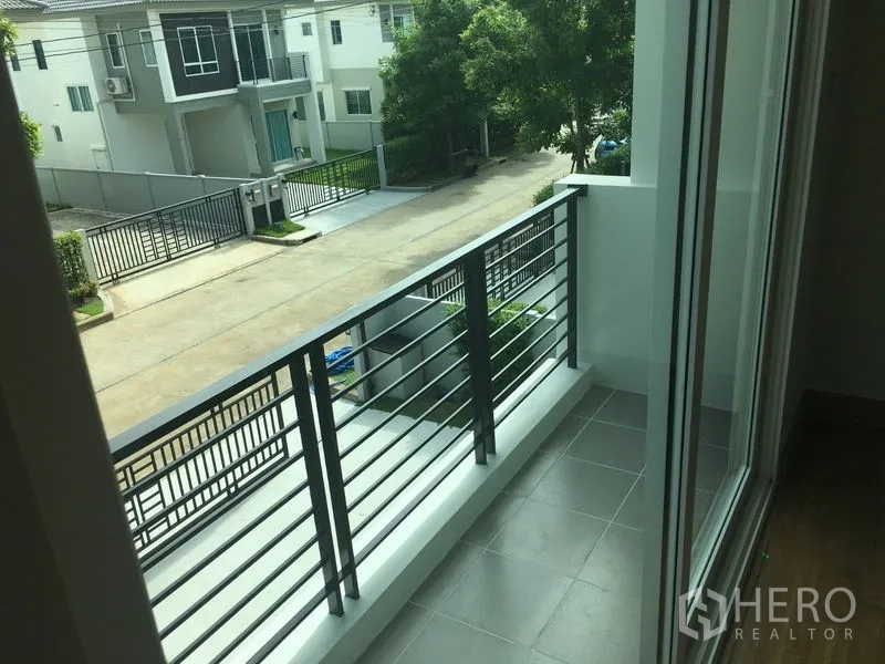 Detached House for rent in Khlong Luang, Pathum Thani - Upper-floor balcony with metal railing overlooking the street.