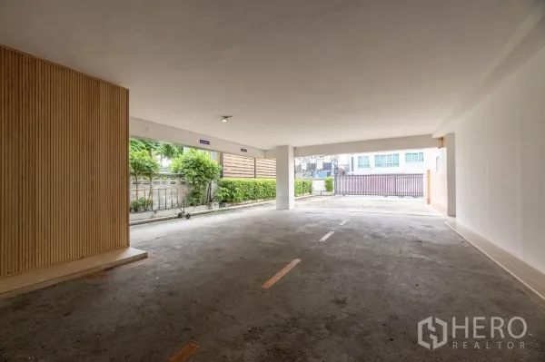 Office Space for rent in Wang Thonglang, Bangkok - Covered ground-level parking area with marked bays and gated entrance.