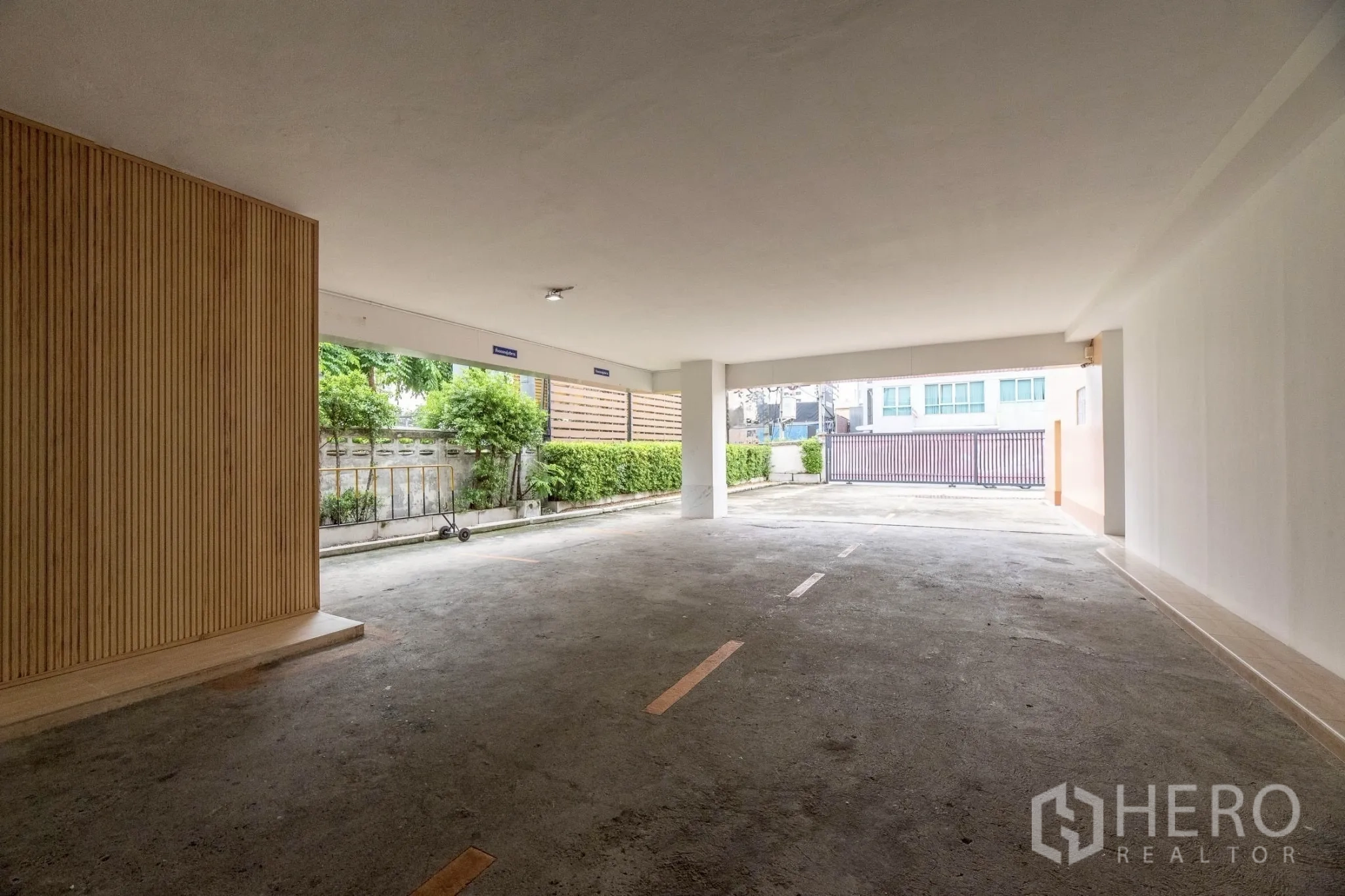 Office Space for rent in Wang Thonglang, Bangkok - Covered ground-level parking area with marked bays and gated entrance.
