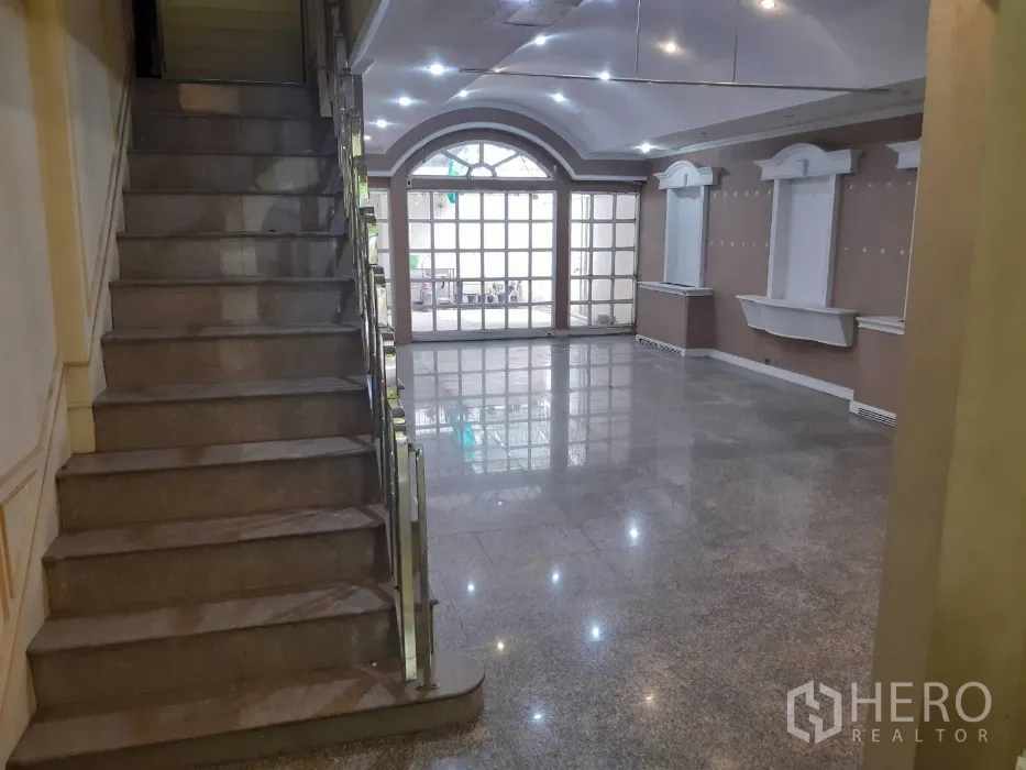 联排别墅 出租在Khlong Toei, Bangkok - 开放式起居区，带楼梯、嵌入式照明与大面积玻璃门。